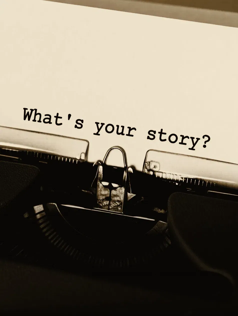 Vintage typewriter with a sheet of paper reading 'What's your story?'